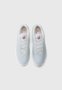 Light blue sneakers with a mesh upper, tonal laces, and a patterned texture. Features visible branding and a cushioned white sole.