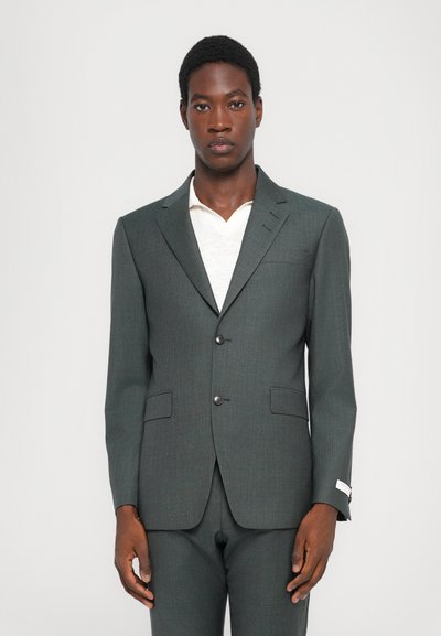 Veste de costume ajustée gris foncé avec une texture subtile, fermeture à un bouton et revers crantés. Comprend deux poches avant et une doublure intérieure contrastante.