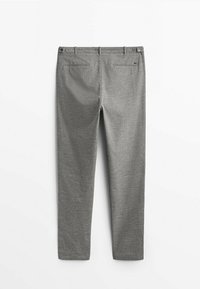 Vue arrière d’un pantalon gris sur mesure avec passants pour ceinture et deux poches passepoilées sur fond blanc.
