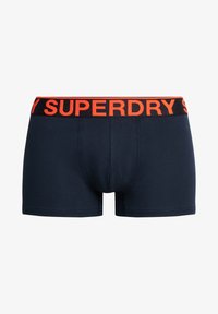 Boxers de algodón en color navy con una ancha cinturilla negra que presenta "SUPERDRY" en letras naranjas. Textura suave y diseño ajustado.