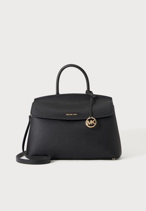 Μαύρη τσάντα Michael Kors με επάνω λαβή, λουράκι χιαστί και χρυσό γούρι με το λογότυπο MK σε απλό λευκό φόντο.