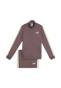 Chándal Puma en color malva con chaqueta de cremallera completa que presenta rayas blancas en las mangas y pantalones a juego con rayas laterales blancas y logotipos de Puma.