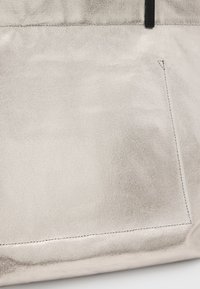 Borsa tote metallizzata argento con superficie textured, design minimalista, dettagli neri e una singola tasca esterna.