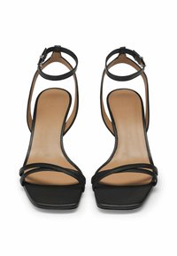 Black leather heeled sandals with a square toe, featuring thin cross straps and a slender ankle strap with adjustable buckle.