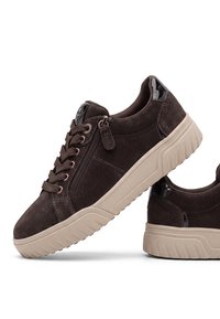 Baskets en daim marron foncé avec semelles épaisses en caoutchouc beige, lacets, fermeture éclair latérale et accents noirs brillants au talon, vues de côté et de dos.