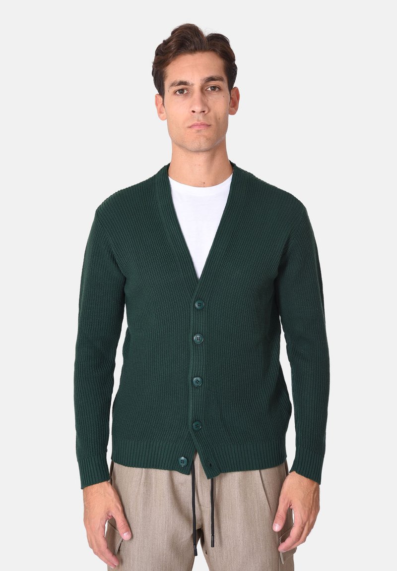 Cardigan verde scuro a coste con scollo a V, cinque bottoni e maniche lunghe. Realizzato in tessuto spesso e strutturato, presenta spacchi laterali.