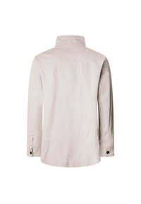 Camicia a maniche lunghe in lino beige chiaro con colletto alta, caratterizzata da un taglio dritto, polsini con bottoni e un design minimalista.