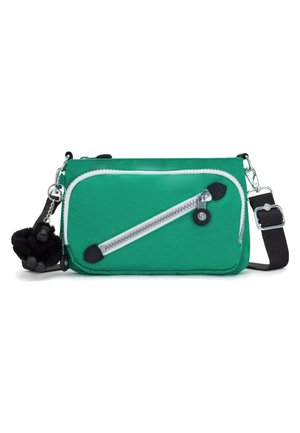 Bolso cruzado de tela verde con un zipper blanco, detalles en negro y un llavero de mono negro extraíble. Incluye correa ajustable.