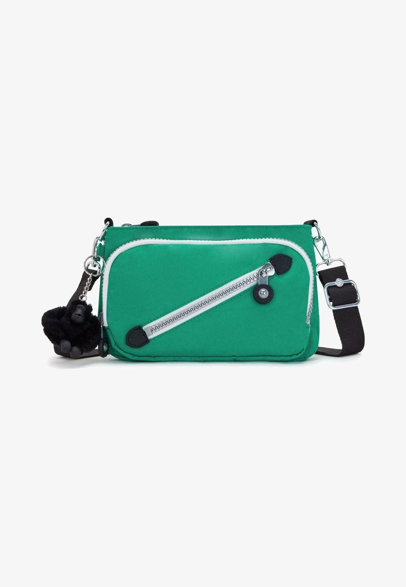 Zelená textilní crossbody taška s bílým zipem, černými detaily a odnímatelným černým přívěskem ve tvaru opičky. Součástí je nastavitelný popruh.