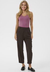 Fitted ribbed purple tank top with scalloped neckline paired with brown high-waisted trousers and black loafers. Minimalist design, smooth texture.
