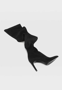 Black suede over-the-knee high heel boot with a pointed toe, featuring a draped design and a stiletto heel. Smooth texture throughout.