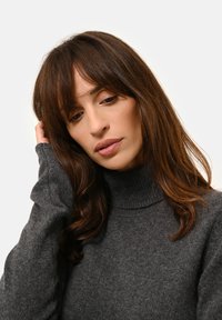 Donkergrijze turtlenecktrui gemaakt van zacht breimateriaal. Beschikt over lange mouwen en een geribbelde halslijn, met een casual en ontspannen pasvorm.