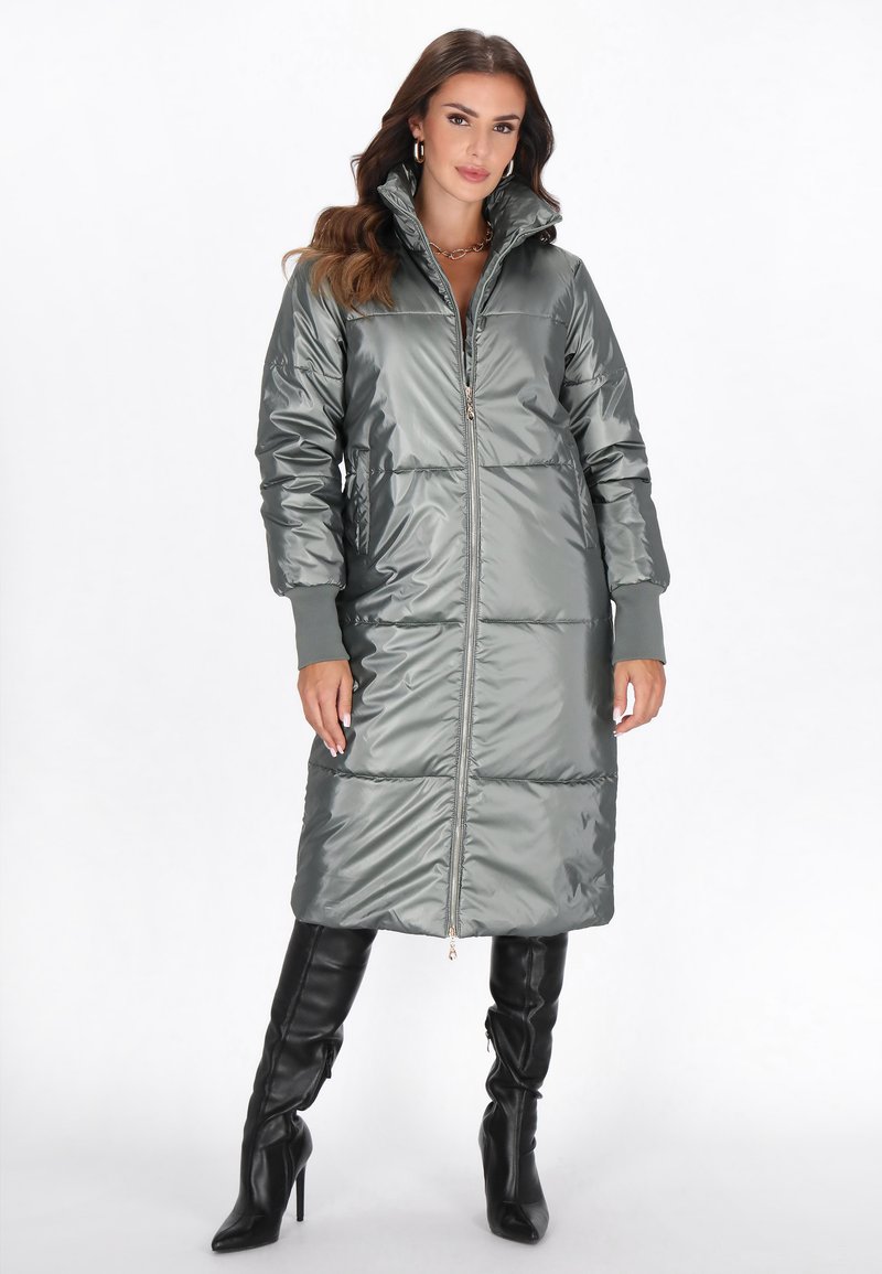 Metallic grøn puffy frakke med lynlås foran, høj krave og lange ærmer. Har quiltet syninger og ribbede manchetter.