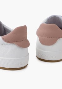 Sneakers bianchi in pelle con dettagli in pelle rosa sul tallone, dotati di suole in gomma testurizzata e nome del marchio impresso di lato.