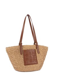 Sac cabas en paille tressée avec poignées en cuir marron et patch en cuir embossé portant la mention "LANCASTER" sur le devant.