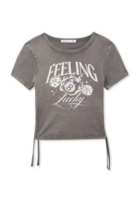 T-shirt cropped grigio a maniche corte con scollatura tonda, caratterizzata da una grafica frontale con la frase "Feeling Lucky" e motivi a dadi. Sono inclusi cordini laterali.