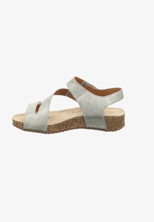 Silberne Leder-Sandalen mit offener Zehenpartie und gekreuzten Riemen. Korksohle sorgt für Textur. Minimalistisches Design mit flachem Profil.