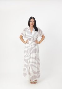 Robe maxi en tissu léger et fluide ; présente des rayures grises abstraites sur fond blanc ; décolleté en V et taille élastique pour un bon ajustement ; manches courtes.