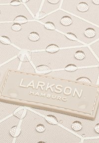 Svetlo béžový materiál s geometrickým vzorom, obsahujúci jasné kvapôčky a obdĺžnikovú nálepku s embosovaným nápisom "LARKSON HAMBURG".