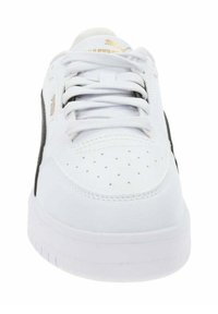 White sneaker with black accents, smooth leather upper, perforated toe for breathability, and flat rubber sole. Laces are centrally positioned.