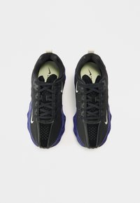 Μαύρα αθλητικά παπούτσια με μοβ λεπτομέρειες, επάνω μέρος από δίχτυ και συνθετικό υλικό, σχέδιο με κορδόνια, επέν�δυση στο πέλμα και χαρακτηριστικό λογότυπο στη γλώσσα.