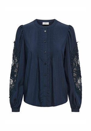 Blusa azul marino de botones con mangas abullonadas y un intrincado detalle de encaje. Tejido suave y liso con pliegues verticales en la parte delantera.