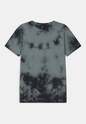 T-shirt à manches courtes avec col rond, motif tie-dye noir et gris et une petite étiquette de marque noire près de l'ourlet inférieur.