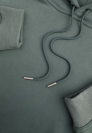 Capuchon sweatshirt van donkergr groen stof met ribgebreide manchetten. Bevat bijpassende trekkoorden met metalen uiteinden, plat gelegd voor de zichtbaarheid.