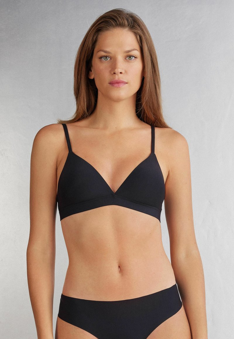 Svart triangulär bh med tunna justerbara band, sömlöst design och mjukt tyg. Matchas med svarta trosor.