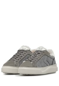 Zapatillas grises con fieltro texturizado y acentos de cuero liso, con un forro suave, cordones en la parte frontal y suela de goma estriada.