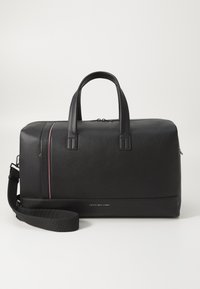 Black leather duffel bag with textured surface, dual handles, adjustable strap, and subtle red and white accent stripe along the zipper.