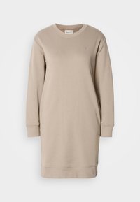 Beiges Sweatshirt-Kleid mit langen Ärmeln, Rundhalsausschnitt und gerippten Bündchen. Verfügt über ein kleines Logo auf der Brust und besteht aus weichem Stoff.