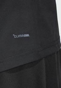 Tricou sportiv negru cu brandul ClimaCool, având o textură netedă și tiv cusut. Materialul este respirabil și ușor.