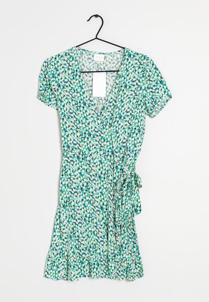 Wikkeljurk met korte mouwen in groen, wit en blauw bloemenpatroon, hangend aan een zwarte hanger tegen een witte achtergrond.