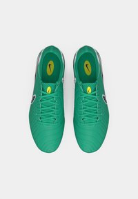 Green soccer shoes with a textured upper, black swoosh, and yellow accents. Features a lace-up design and cushioned insole for comfort.