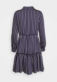 Abito blu navy con strisce bianche verticali, colletto, maniche lunghe, vita elasticizzata e orlo arricciato. Realizzato in un tessuto liscio.