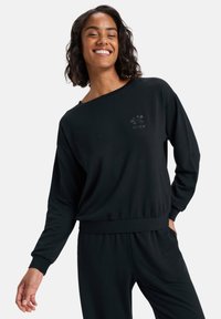 Zwarte sweatshirt gemaakt van zacht materiaal, met een ontspannen ontwerp, brede hals, geribde zoom en een reliëflogo op de borst.