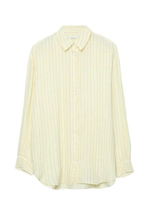 Pitkähihainen, vaaleankeltainen nappipaita, jossa ohuita pystysuoria mustia raitoja ja terävä kaulus, aseteltu tasaisesti valkoiselle taustalle.