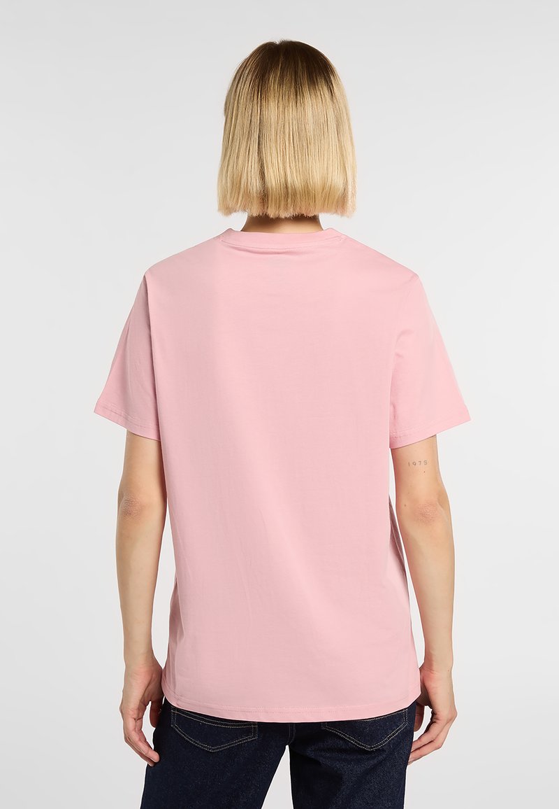 Roze T-shirt met korte mouwen, katoenen stof, ontspannen pasvorm, ronde halslijn, effen ontwerp en naadloze schouders, gedragen met donkere denim jeans.