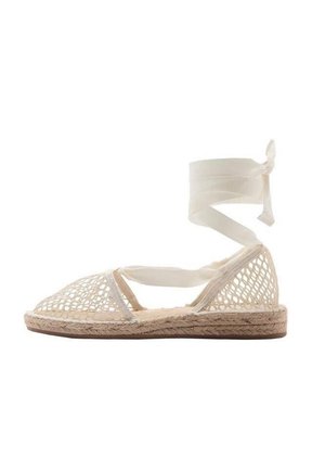 Białe plecione espadryle z jutową podeszwą, z sznurowanymi paskami wokół kostki i otwartym noskiem. Oddychająca struktura z płaskim profilem.
