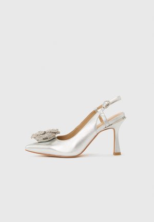 Silver slingback high heel shoe with pointed toe and large decorative pearl embellishment on front.
