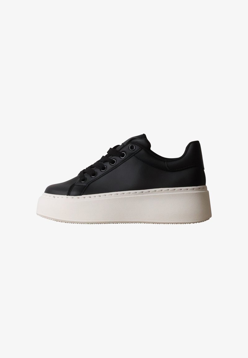 Baskets plateformes en cuir noir avec lacets noirs et semelle blanche épaisse vues de côté sur fond blanc.
