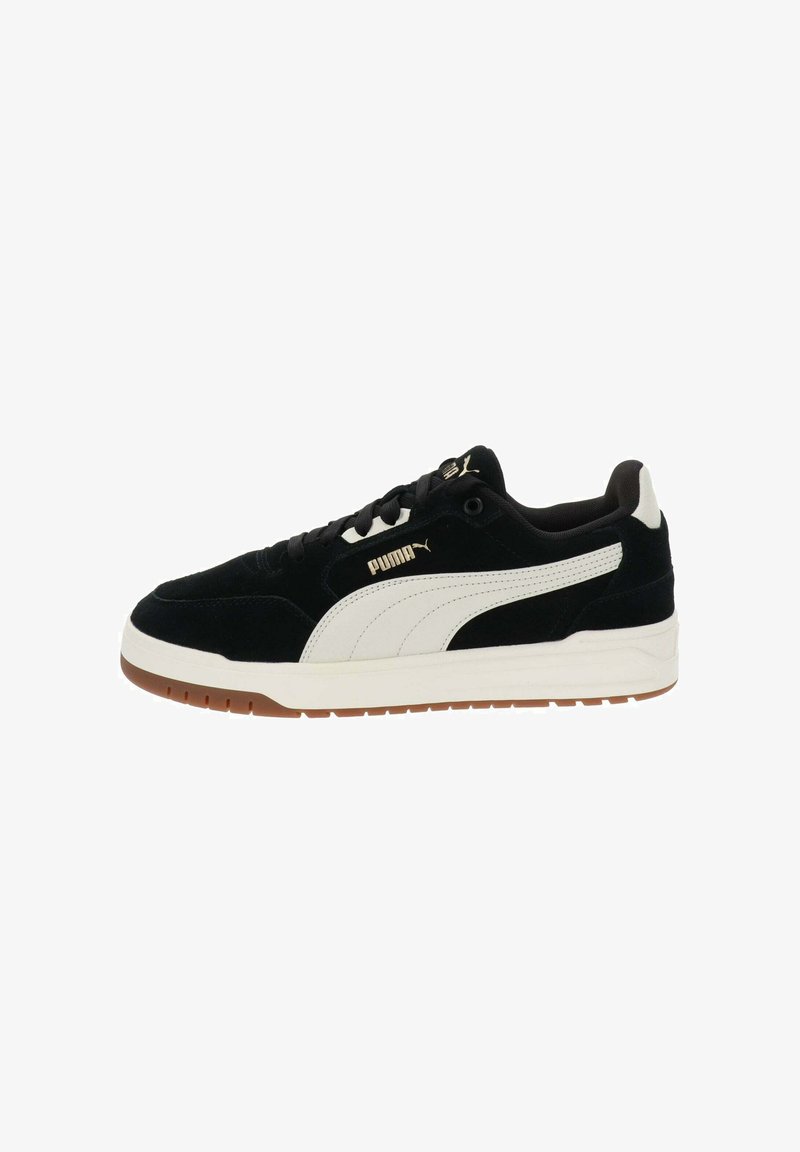 Zapatillas de ante negras con acentos en cuero blanco y suela de goma beige. Presentan un diseño de cordones y una sutil marca en el costado.