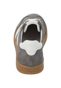 Sneaker en daim gris, avec un accent en cuir blanc au talon et aux lacets. La semelle est en caoutchouc marron clair, avec une texture lisse.