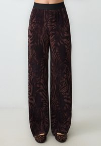 Dunkle, plissierte, weit geschnittene Hosen mit Zebramuster, ausgestattet mit einem schwarzen Bund und einer glatten Textur. Farbzusammenstellung in Braun und Schwarz.