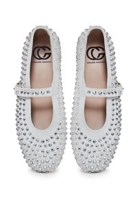 Scarpe Mary Jane in camoscio bianco con punta arrotondata, abbellimenti con borchie e una fascia orizzontale con chiusura a fibbia.