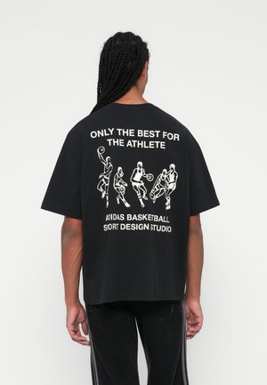 Sort oversized t-shirt med et hvidt grafisk print af basketballspillere og tekst på ryggen, med rund halsudskæring og korte ærmer.