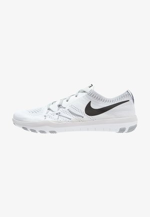 Scarpe sportive bianche con tomaia in rete, dettagli grigi e un grande logo Nike nero. La suola è strutturata con pattern antiscivolo.