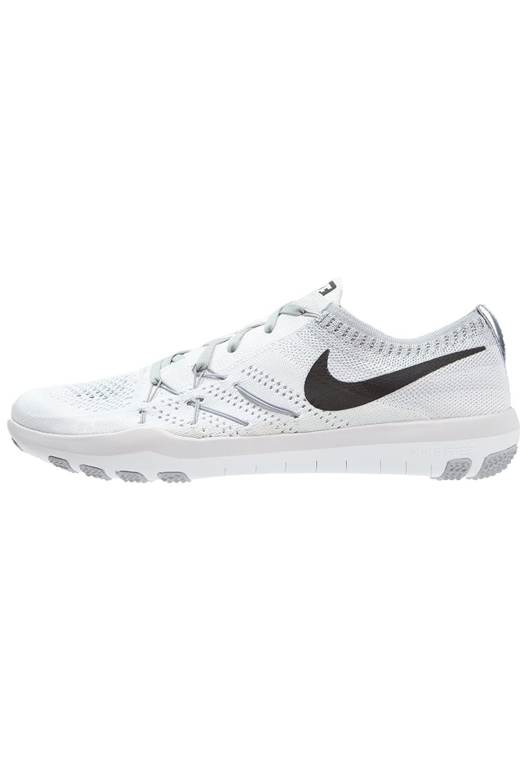 Białe buty sportowe z siateczkową cholewką, szarymi akcentami i wyraźnym czarnym logo Nike. Podeszwa ma fakturę z wypustkami zapewniającymi przyczepność.