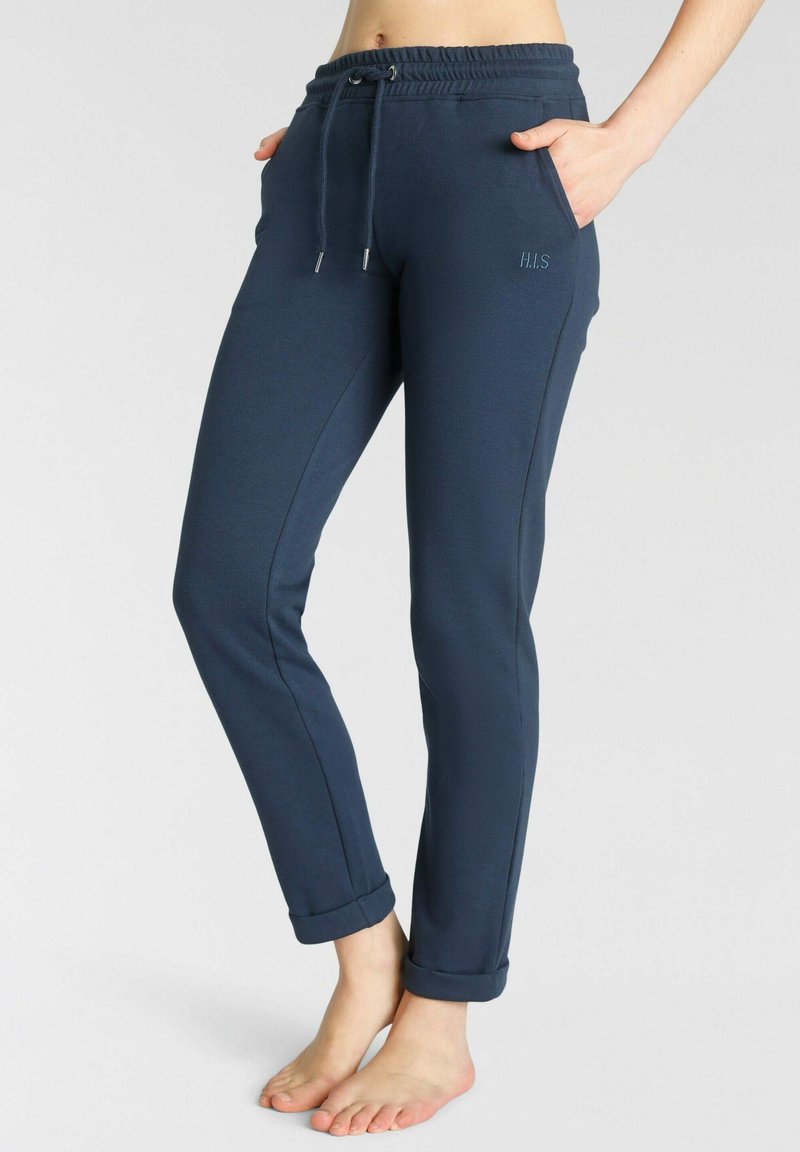 Pantalones jogger azul marino hechos de tejido suave, con cintura ajustable mediante cordón, puños enrollados y bolsillos laterales. Logo bordado en la parte frontal.